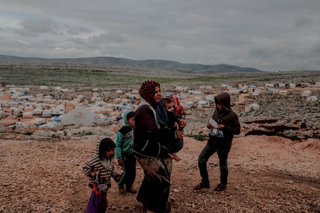 muslim ethnic mother with baby in arms and children around